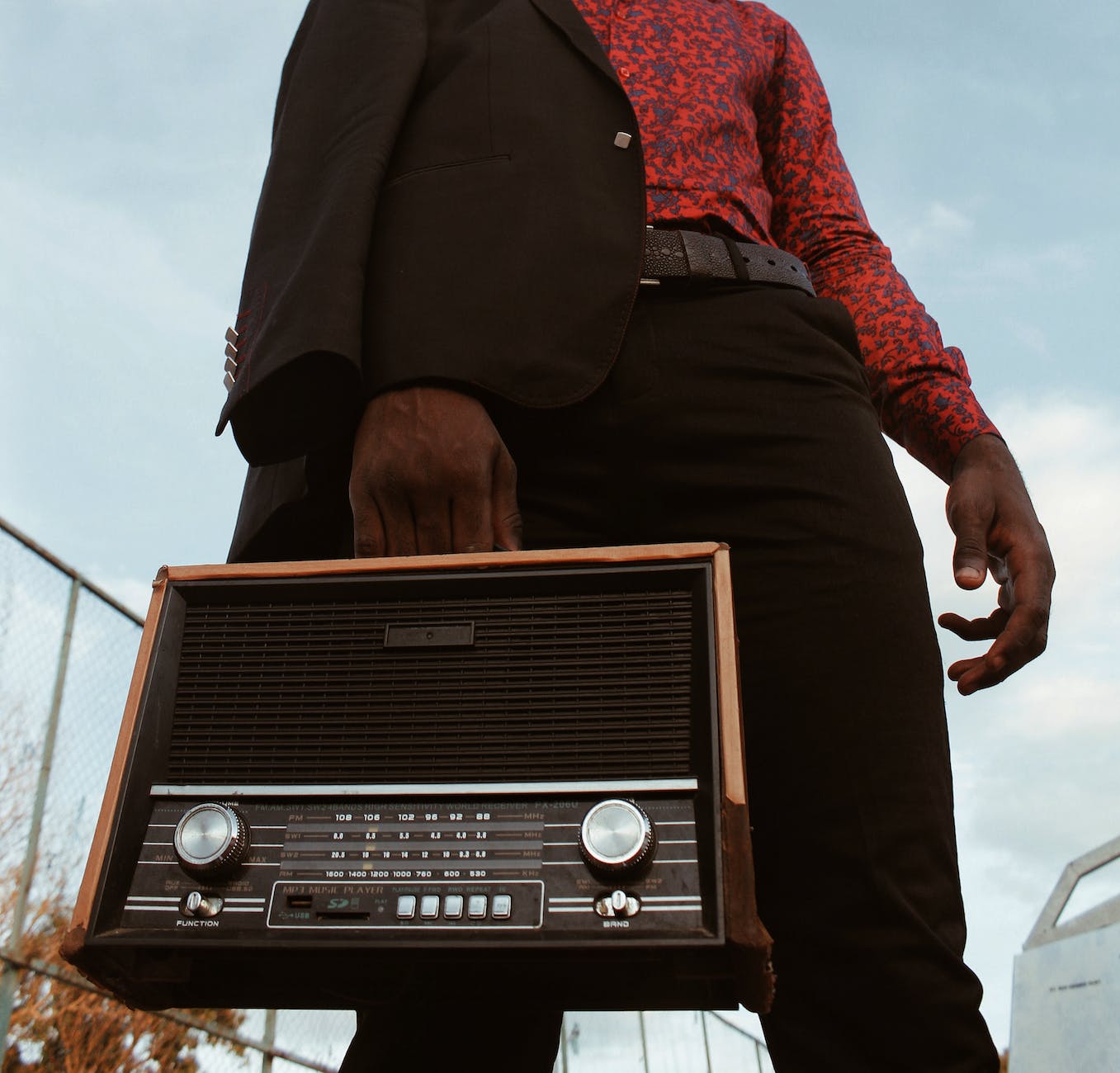 low angle photography of man carrying a short wave radio